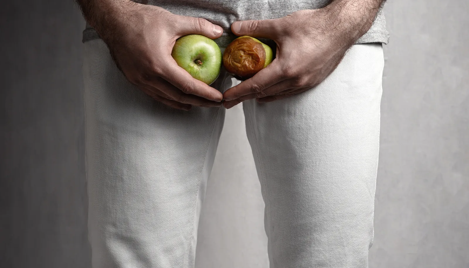 Man holding two apples, a symbolic image of male fertility